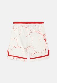 Shorts blancs avec motif craquelé rouge, rayures rouges à la taille, et bordure rouge le long des bords inférieurs sur un fond clair uni.