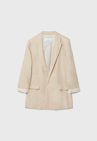 Beige linnen blazer met een diepe V-hals, opgerolde mouwen met gestreepte manchetten en twee voorzakken. De textuur lijkt soepel en lichtgewicht te zijn.