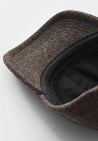 Braune Wollmütze mit weicher Textur, ausgestattet mit einem schwarzen Futter und einem gebogenen Schirm. Die Innenseite ist glatt und zeigt Nahtdetails am Rand.
