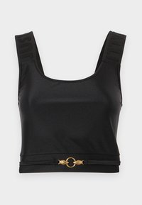Top corto nero realizzato in tessuto morbido. Presenta spalline larghe con testo in rilievo e un accento circolare dorato all'orlo. Design semplice e raffinato.