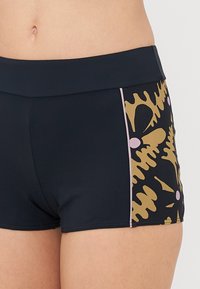 Black swim shorts with a patterned side featuring gold, pink, and black designs, a wide waistband, and a smooth texture.