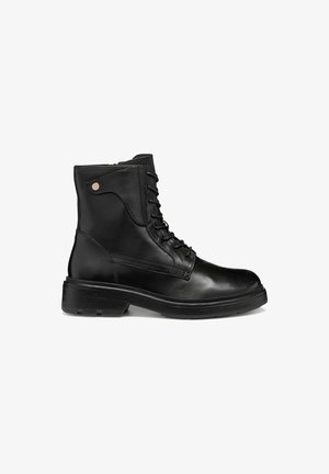 Bottines en cuir noir avec un bout arrondi, un laçage à l'avant et une semelle en caoutchouc texturée de faible hauteur ; dotées d'un accent métallique décoratif sur le côté.