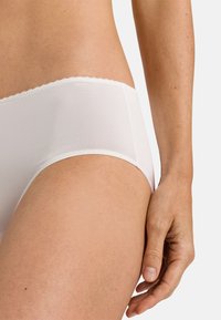 Witte katoenen hipsterondergoed met een golvende tailleband. Soepele textuur, mid-rise ontwerp en minimale naden voor comfort en pasvorm.