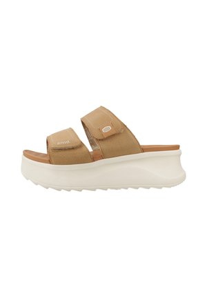 Sandale mule beige avec deux brides réglables et une épaisse semelle plateforme blanche, dessus en cuir texturé et semelle intérieure rembourrée.