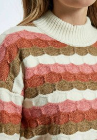 Sweter robiony na drutach z żeberkowym dekoltem, z teksturowanym falistym wzorem w kolorach kremowym, różowym, rdzawego i brązowym, z różnymi grubościami włóczki.