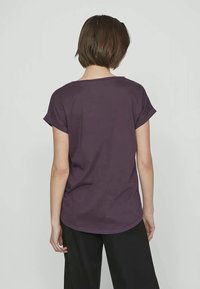 Μωβ T-shirt με κοντά ρολάριστα μανίκια, χαλαρή γραμμή και στρογγυλή ραφή. Φτιαγμένο από μαλακό ύφασμα, κατάλληλο για καθημερινές εμφανίσεις.