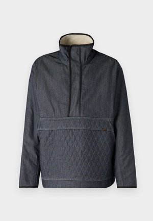 Dark denim pull-over jacket with a high collar, quilted diamond pattern at the front, and a soft interior lining. Black accents along edges.