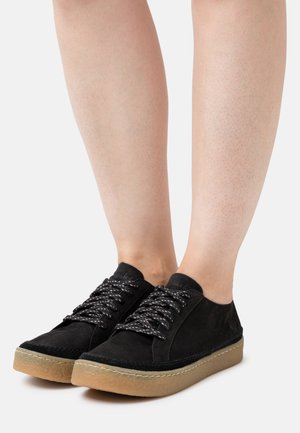 Des baskets lacées en suède noir présentent un bout rond, un dessus texturé et une semelle en caoutchouc brun clair. Agrémentées de lacets à motifs et d'une marque minimale.