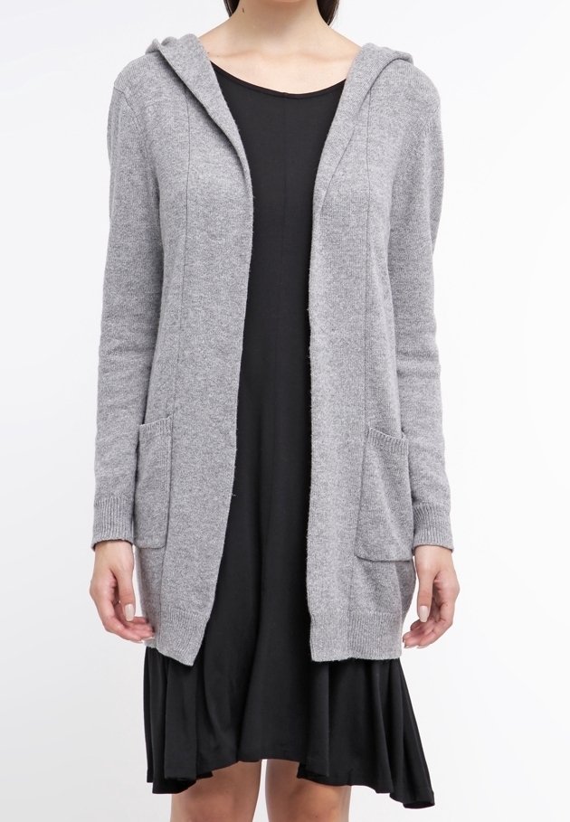 Cardigan grigio a maglia con cappuccio, tasche frontali, apertura frontale e polsini a costine. Indossato sopra un vestito nero, evidenziando la sua versatilità.