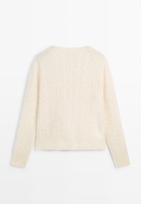 Pull torsadé de couleur crème avec manches longues et encolure, poignets et ourlet côtelés, vu de dos.