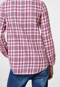 Langärmliges Hemd mit einem pink, weißen und marineblauen karierter Muster, aus leichtem Stoff mit abgerundetem Saum und knöpfbaren Manschetten.