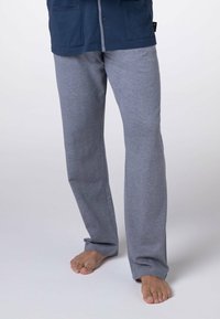 Pantaloni lounge grigi realizzati in tessuto morbido, con una vestibilità comoda, una texture liscia e gambe dritte, abbinati a una camicia blu navy.