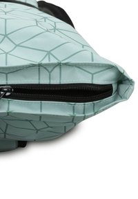 Zelený látkový sáček se vzorem a zapínáním na zip. Má geometrický design a texturovaný povrch. Okraj je pečlivě prošívaný.