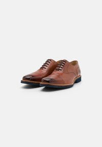 Zapatos de vestir de cuero marrón con puntera pulida, diseño tradicional de cordones, forma ligeramente redondeada y suela de goma azul contrastante.