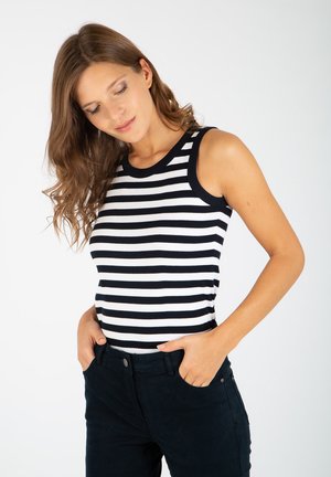 Gestreifter Tanktop mit schwarz-weißen horizontalen Streifen, geripptem Textur und schwarzem Besatz am Ausschnitt, kombiniert mit dunklen Hosen.