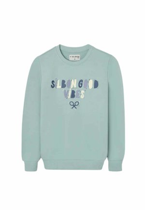 Sudadera azul claro con cuello redondo, con el texto "Silbon Good Vibes" y un pequeño icono de tijeras debajo del texto.