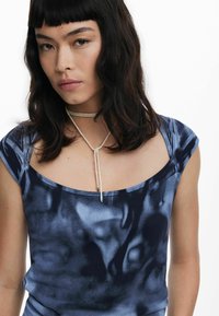 Navy blue tie-dye top featuring a scoop neckline and short sleeves, made of soft fabric with a smooth texture and a decorative cord detail.