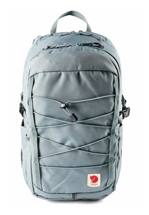 Zaino grigio chiaro con cordini elastici frontali, molteplici scomparti con cerniera, fibbie laterali, maniglia superiore e patch con logo della volpe rossa nella parte inferiore.