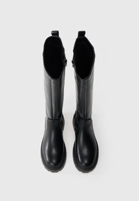 Cizme negre din piele, până la genunchi, cu un finisaj neted, vârf rotund, fermoar pe o parte și talpă din cauciuc texturat. Fără modele sau accente vizibile.