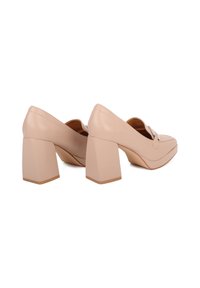 Scarpe con tacco a blocco in pelle beige, dalla punta arrotondata e con un dettaglio a fiocco sulla tomaia. Il tacco ha una forma solida e geometrica.