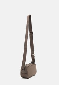 Borsa a tracolla in pelle marrone con forma rettangolare, tracolla imbottita e chiusura con zip. Presenta dettagli del logo e una texture liscia.