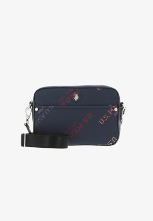 Sac en toile bleu marine slim avec texte rouge et blanc, comprenant un emblème logo argenté, une bandoulière noire réglable et une fermeture éclair.