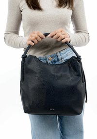 Borsa a mano nera in pelle con texture granulosa, forma rotonda e manico singolo. Presenta una chiusura con zip e un logo sottile.
