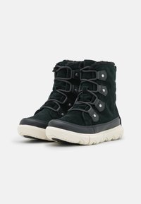 Svarta mocka ankistövlar har en mjuk foder, gummitåhuvud och kontrasterande krämfärgad sula. Snörningssystem med metalldetaljer.