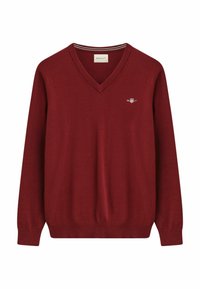 Roter gestrickter Pullover mit V-Ausschnitt, langen Ärmeln, gerippten Bündchen und Saum, versehen mit einem kleinen Logo auf der Brust und gestreiften Details im Kragen.
