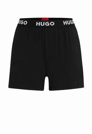 Black boxer shorts made of soft fabric, featuring an elastic waistband with "HUGO" printed in white. Simple, clean design with a mid-thigh cut.