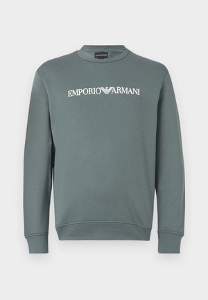 Zaļš kokvilnas sporta krekls ar apaļu kakla izgriezumu un garām piedurknēm, ar "EMPORIO ARMANI" logo baltā krāsā drukātu krūšu daļā.