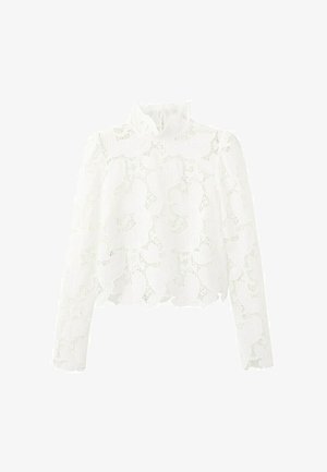 Camicia bianca a maniche lunghe in pizzo con motivi floreali a forma di cuore e colletto alto, con orlo e polsini smerlati.