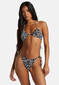 Bikini set in zwart en wit, met een bloemenpatroon. Triangle-top met verstelbare banden en onderkant met gestrikte zijkanten.