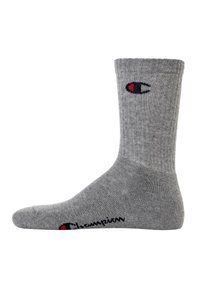 Graue Baumwollsocke mit Rippendesign, einer einfarbigen Zehenpartie und einem roten und schwarzen Logo am Knöchel, ausgestattet mit kontrastierender Textur an Ferse und Zehen.