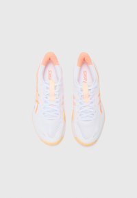 Baskets de sport blanches avec tige en mesh, accents orange et logo. Bout arrondi, design à lacets et semelle en caoutchouc. Contraste de couleurs notable.