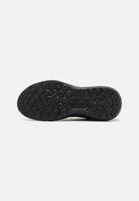 Semelle de chaussure en caoutchouc noir avec motif de bande de roulement texturé conçu pour l'adhérence et la durabilité.