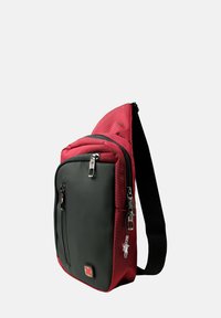 Sac bandoulière rouge et noir fabriqué en tissu durable, comportant un compartiment principal zippé, une poche avant et une sangle ajustable pour un transport facile.