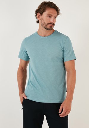Light blue crew-neck t-shirt made of soft, lightweight fabric with short sleeves, featuring a smooth texture and a relaxed fit.