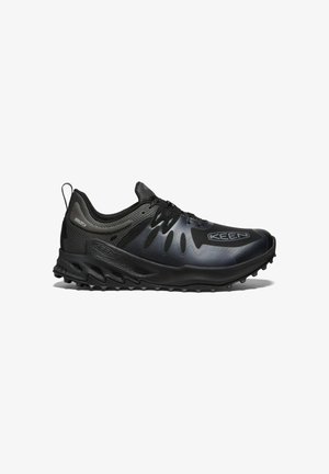 Schwarzer Sportschuh mit Mesh-Obermaterial, strukturierten Akzenten und dicker Gummisohle mit multidirektionalem Profil für besseren Halt. Verstärkter Zehenschutz.