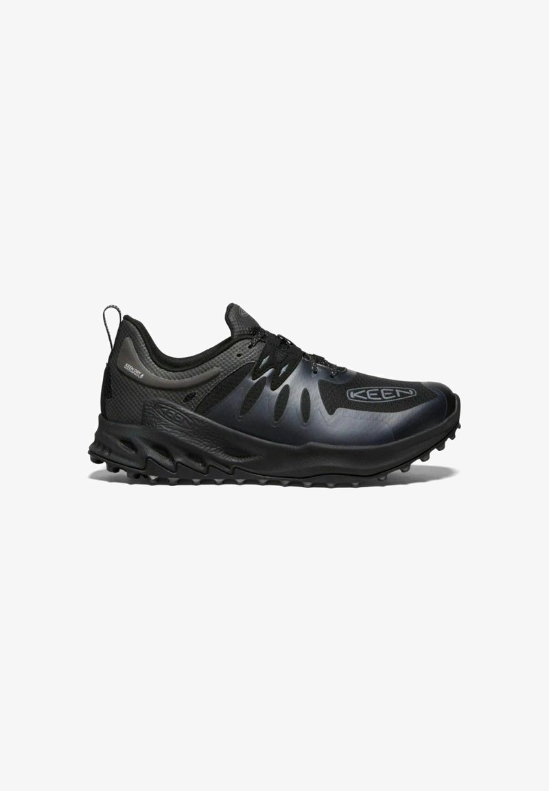 Schwarzer Sportschuh mit Mesh-Obermaterial, strukturierten Akzenten und dicker Gummisohle mit multidirektionalem Profil für besseren Halt. Verstärkter Zehenschutz.