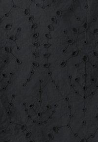 Tessuto ricamato nero con intricati motivi floreali e tralci, caratterizzato da dettagli a intaglio che conferiscono un aspetto tattile.