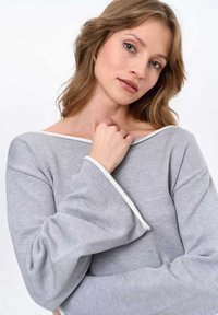 Grey long-sleeve top with a wide neckline and white trim. Features textured fabric and flared sleeves, showcasing a soft, casual design.