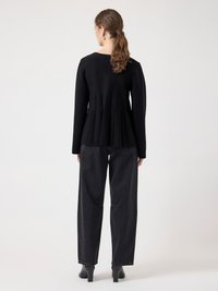 Black knit sweater featuring a pleated back design, paired with high-waisted black jeans and black heeled ankle boots. Simple and sleek.