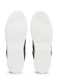 Scarpe da ginnastica nere con suola in gomma bianca. La suola presenta scanalature orizzontali per una migliore aderenza e il marchio è visibile sul tallone.