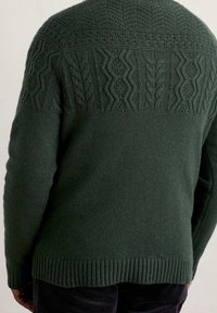 Dunkelgrüner gestrickter Pullover mit strukturierten Mustern auf den Schultern, geripptem Saum und Bündchen. Weicher Stoff mit warmer Ausstrahlung.