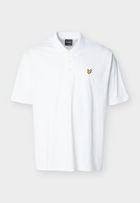 Λευκό κοντομάνικο πόλο πουκάμισο με γιακά, τρία κουμπιά και μικρό κίτρινο λογότυπο πουλιού στο αριστερό μέρος του στήθους.