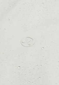 Bijela tkanina s kapljicama vode i kružnim bijelim logotipom s valovitim dizajnom u središtu. Glatka tekstura s laganim sjajem.
