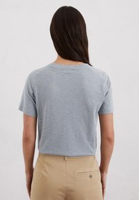 Lichtgrijs kortekorte mouw T-shirt gemaakt van zachte stof, met een ronde halslijn en een ontspannen pasvorm, gezien van de achterkant.