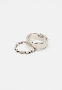 Twee zilveren ringen die elkaar overlappen: de ene is eenvoudig met een gladde afwerking, de andere is gedraaid met een gestructureerd oppervlak. Beide zijn metallic en gepolijst.