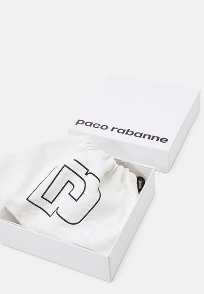 Baltas dėžutė su juodu užrašu "paco rabanne". Viduje yra balta raištelių maišelį, kuriame yra išraiškingas juodas grafikų dizainas.
